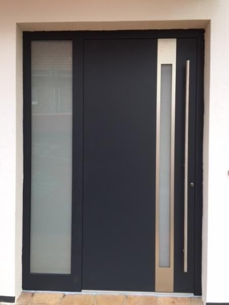 Eine schwarze Tür mit einem Edelstahlgriff