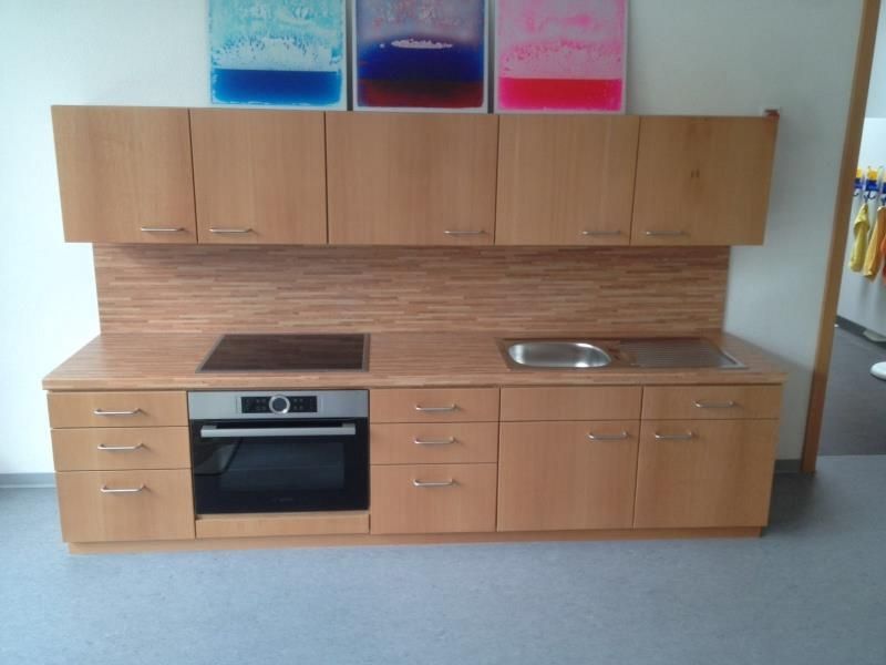 Eine Küche mit Geräten aus Edelstahl und Holzschränken