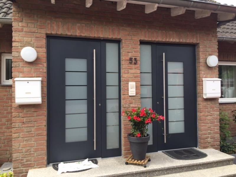 Die Eingangstür eines Backsteinhauses mit einer schwarzen Tür