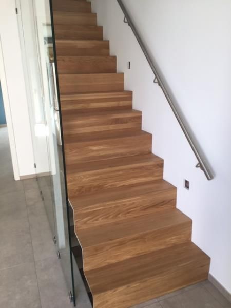 Eine Holztreppe mit Edelstahlgeländer