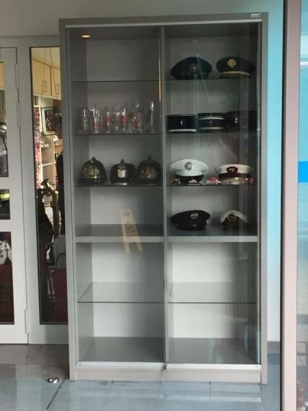 Eine Glasvitrine voller Hüte und Brillen