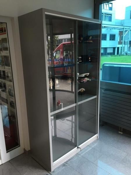 Eine Vitrine mit Glasschiebetüren in einem Raum