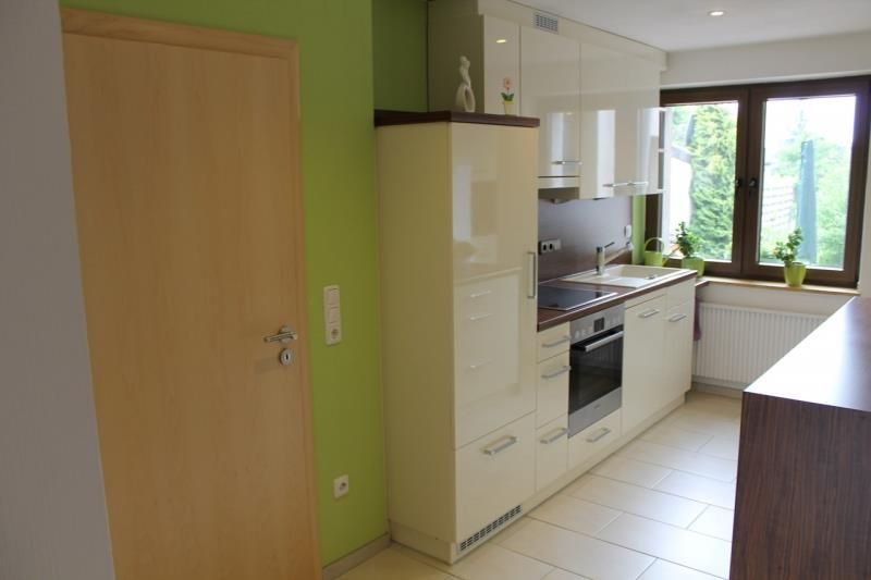 Eine Küche mit weißen Schränken und einer grünen Wand