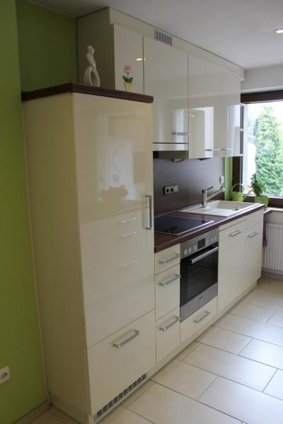 Eine Küche mit weißen Schränken und einer grünen Wand