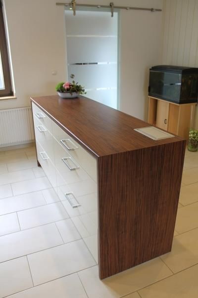 Eine Kommode mit Schubladen und einer Holzarbeitsplatte in einer Küche.