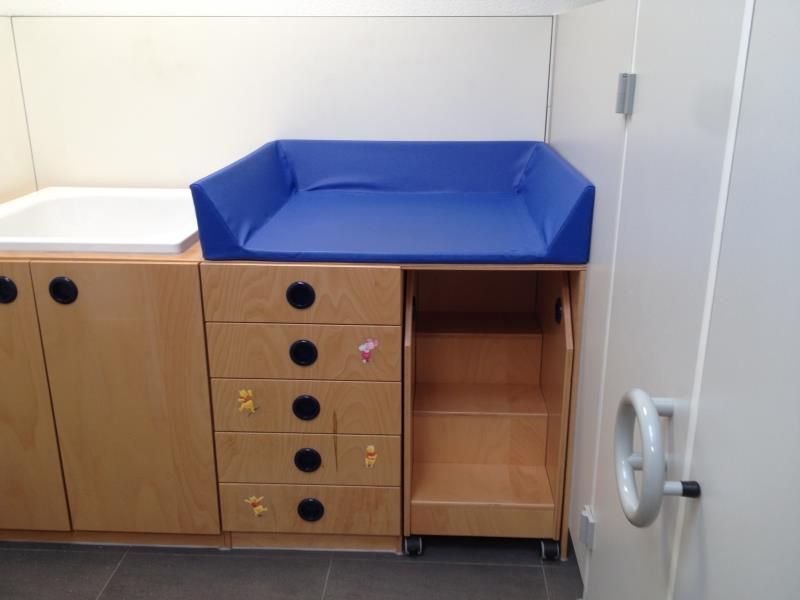 Ein Wickeltisch mit einem blauen Kissen darauf