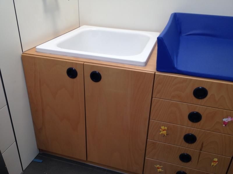 Ein Badezimmer mit Waschbecken und blauem Wickeltisch