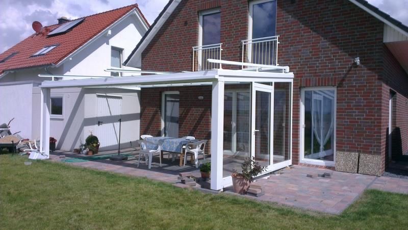 Ein Backsteinhaus mit einer weißen Terrasse davor