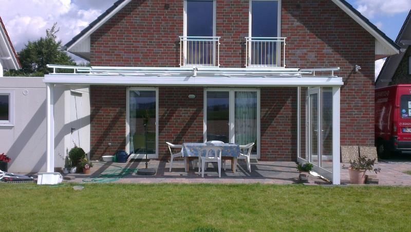 Ein roter Lieferwagen steht vor einem Backsteinhaus