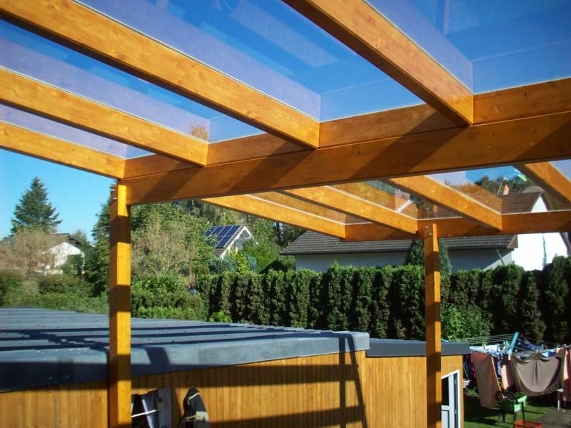 Eine Holzkonstruktion mit einem Dach aus klarem Glas