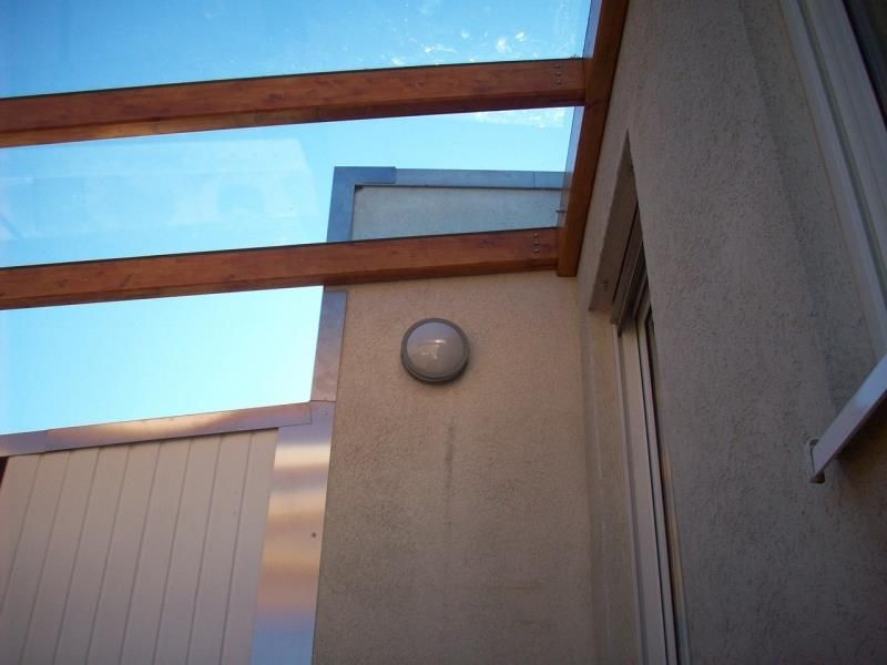 Ein Licht an der Seite eines Gebäudes mit einem blauen Himmel im Hintergrund