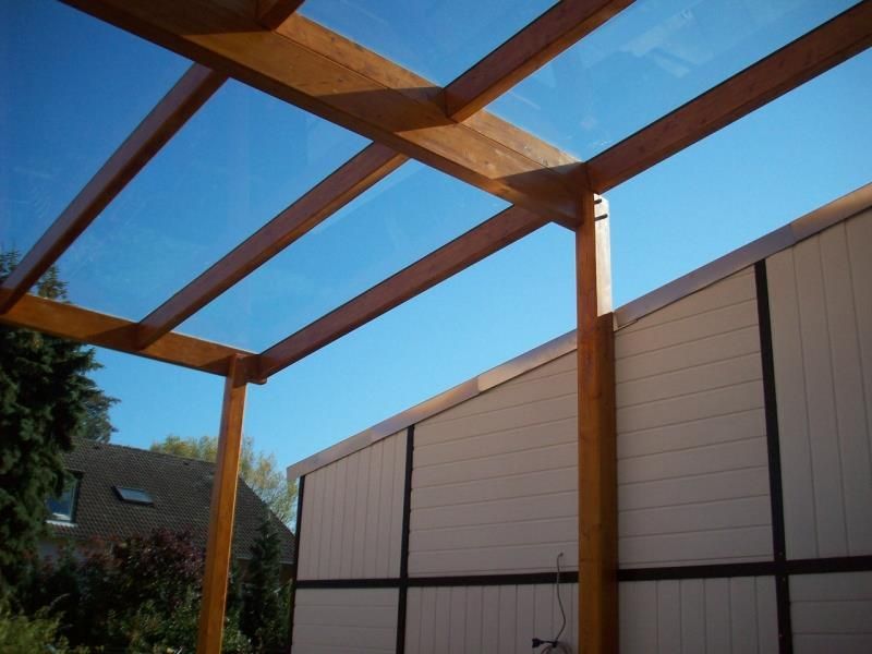 Eine Holzkonstruktion mit einem Dach aus klarem Glas