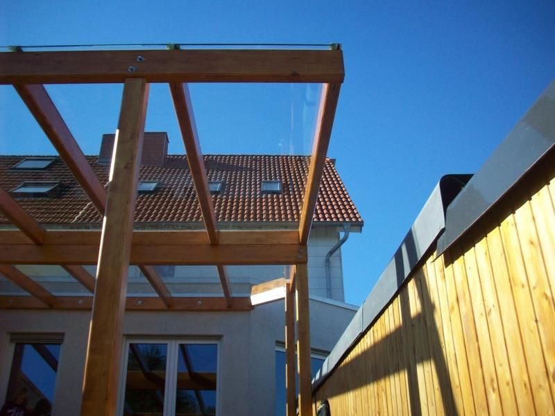 Ein Haus mit einem Holzzaun und einem Glasdach