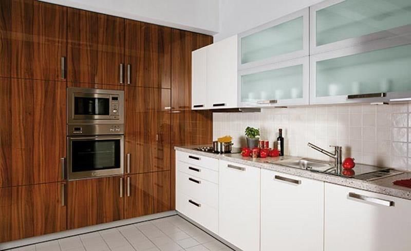 Eine Küche mit weißen Schränken und Holzschränken