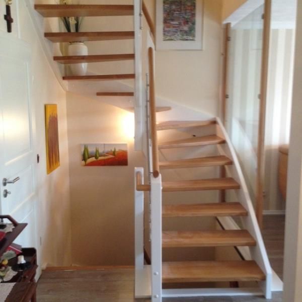 Eine Holztreppe mit einem weißen Geländer in einem Flur