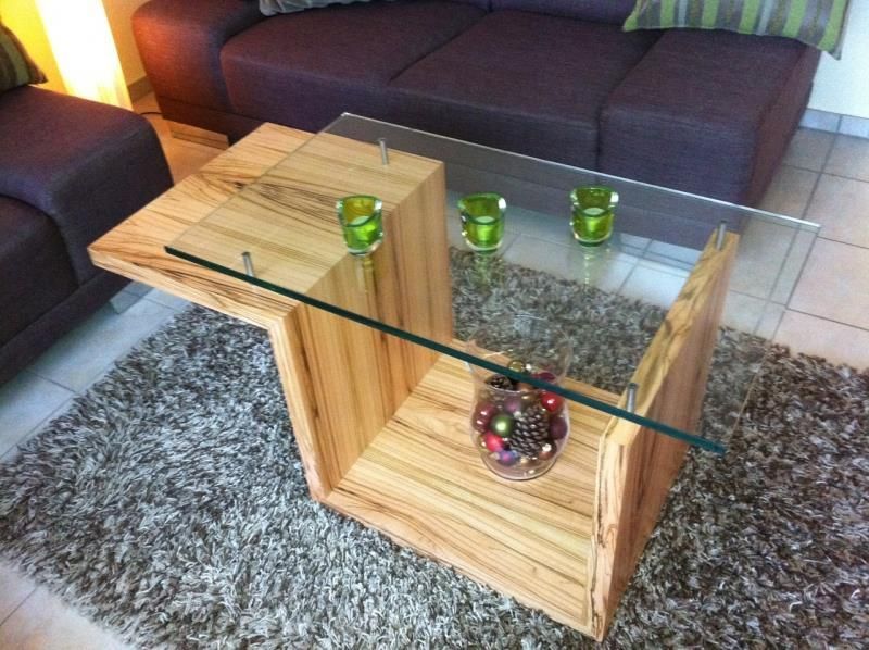 Ein Holztisch mit Glasplatte in einem Wohnzimmer