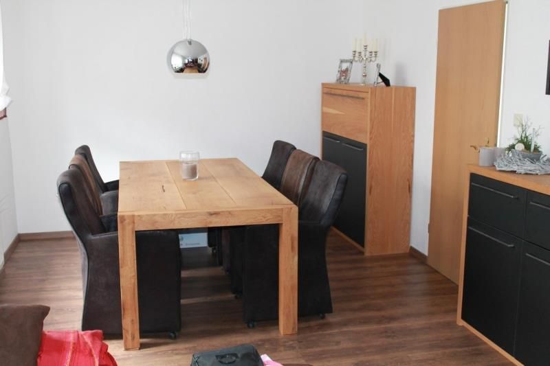 Ein Wohnzimmer mit einem Holztisch und Stühlen