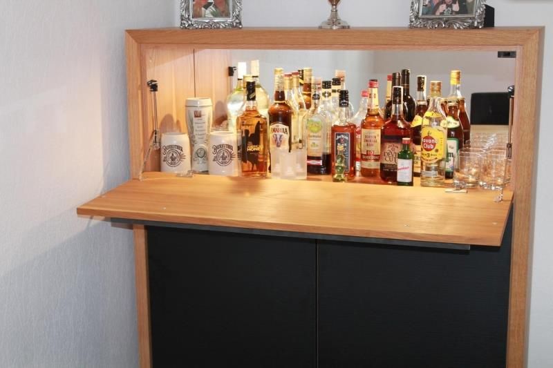 Ein Holzschrank mit Schnapsflaschen darauf