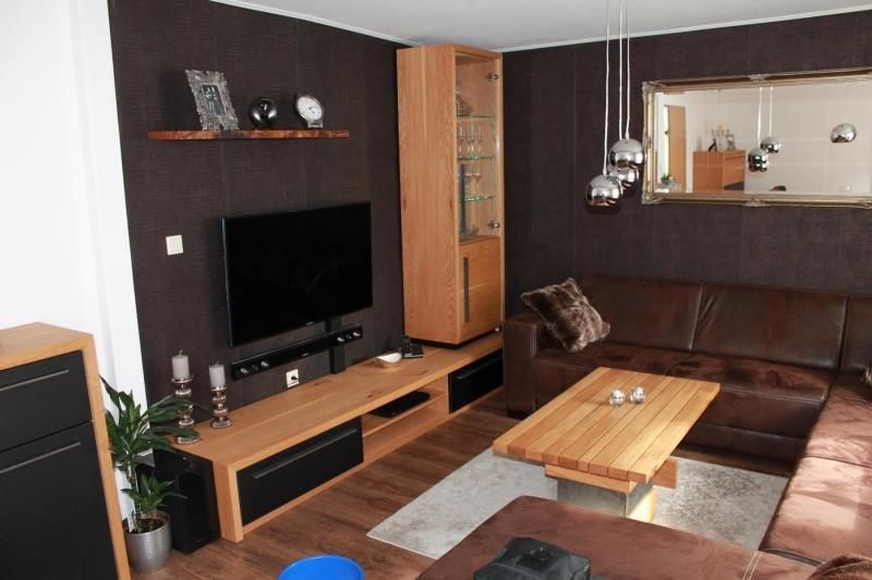 Ein Wohnzimmer mit braunen Möbeln und einem Flachbildfernseher