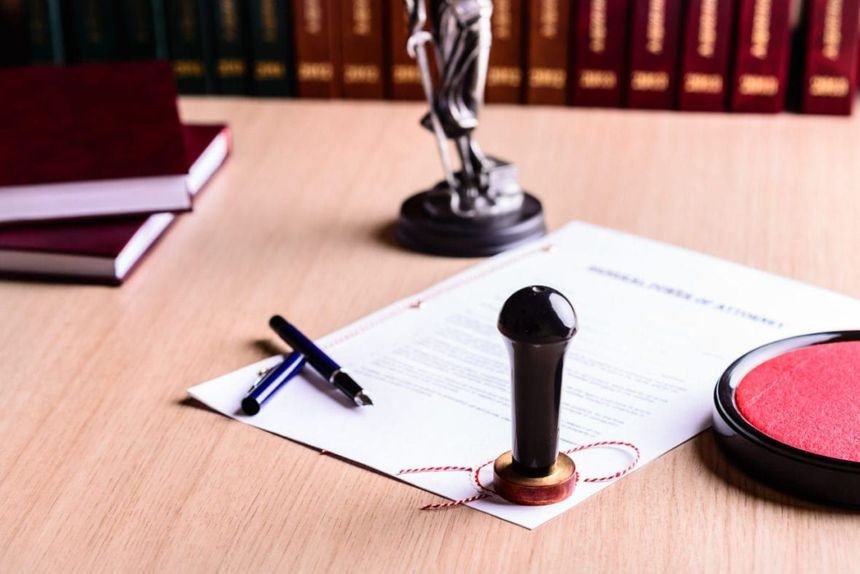 Una estatua de la justicia está sentada en una mesa junto a un sello y un bolígrafo.