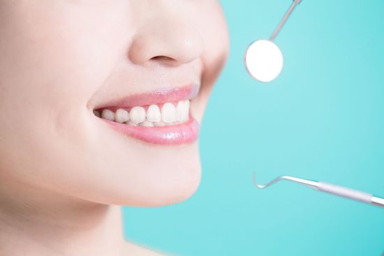 Una mujer está siendo examinada por un dentista.