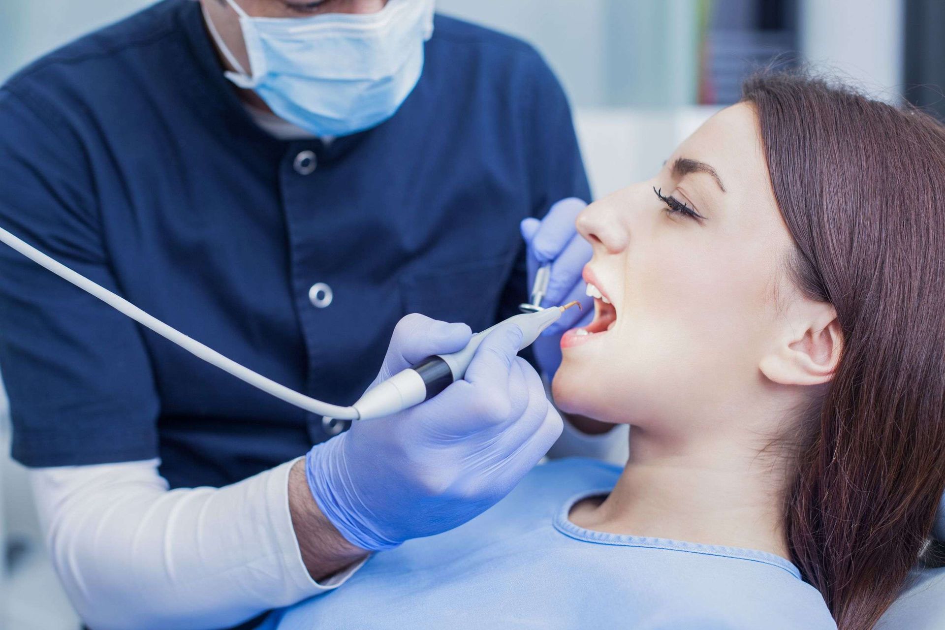 Una mujer está siendo examinada por un dentista.