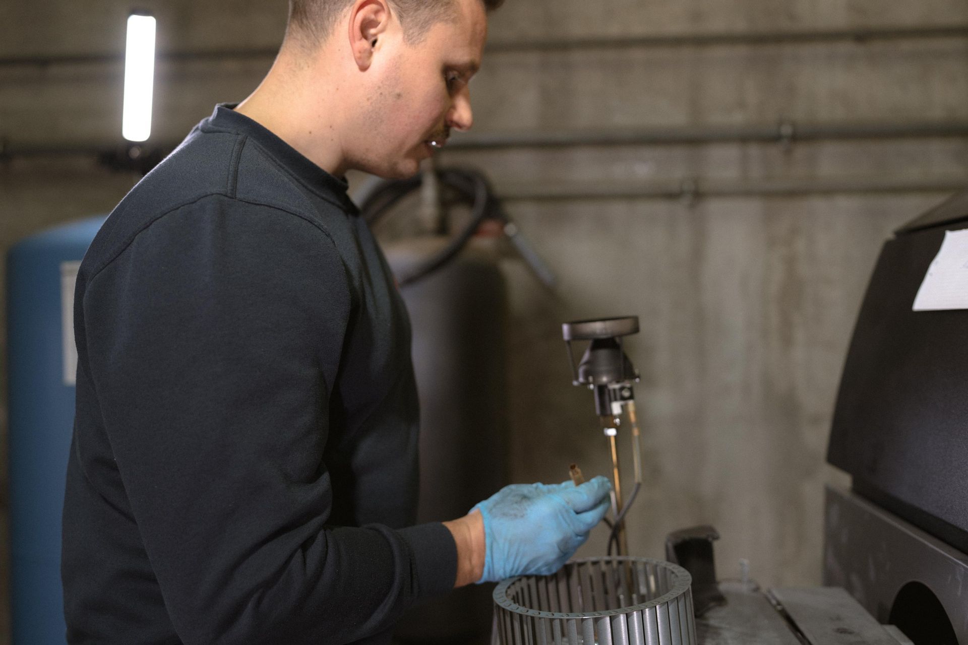 Weisser Warmwasserbereiter mit rotem Ausdehnungsgefäss und Verteilersystem vor Holzvertäfelung.