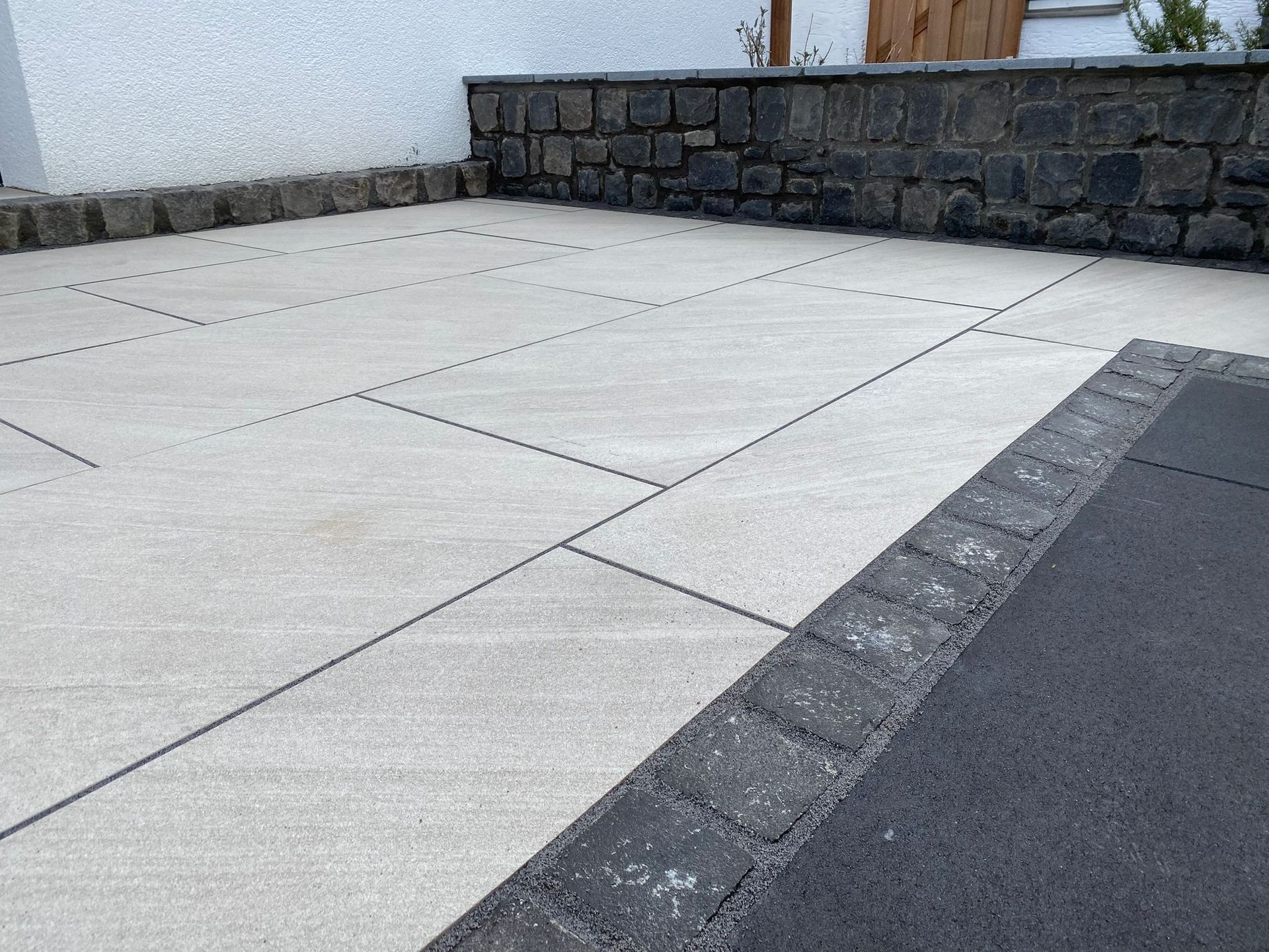 Garten mit Ziegel- und Steinwegen, grünem Rasen und Blumenbeeten.