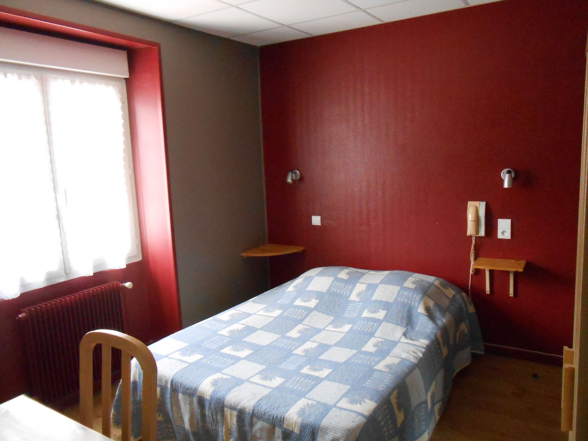 Chambre avec un lit double avec une couverture bleue et blanche