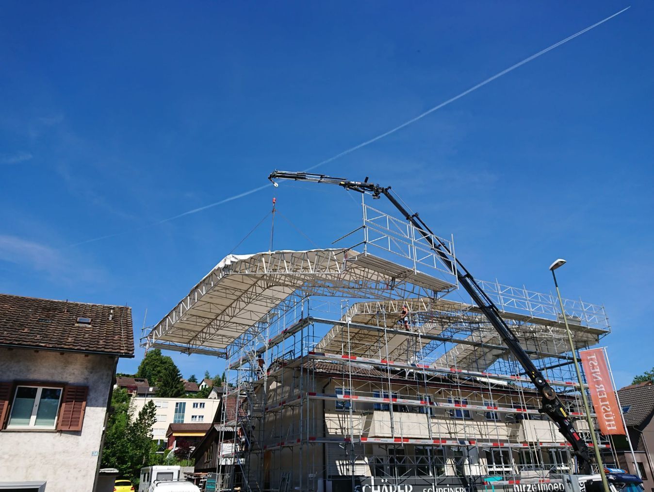 Elmer Gerüstbau über einem Hausdach