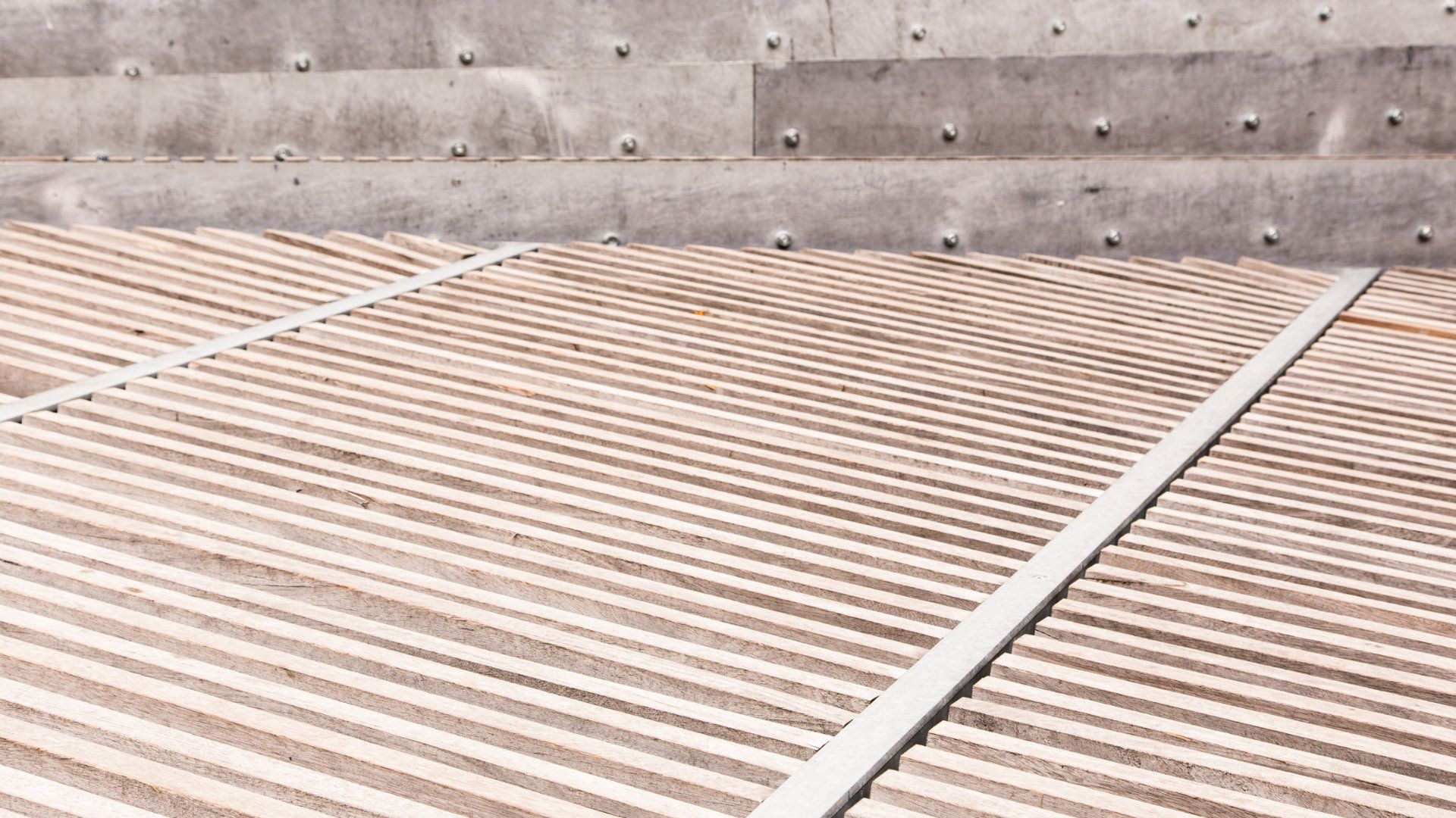 Un primer plano de un techo de metal con una pared de hormigón al fondo.