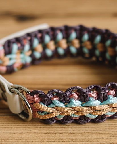 Bracelet tressé multicolore avec fermoir en métal sur une surface en bois
