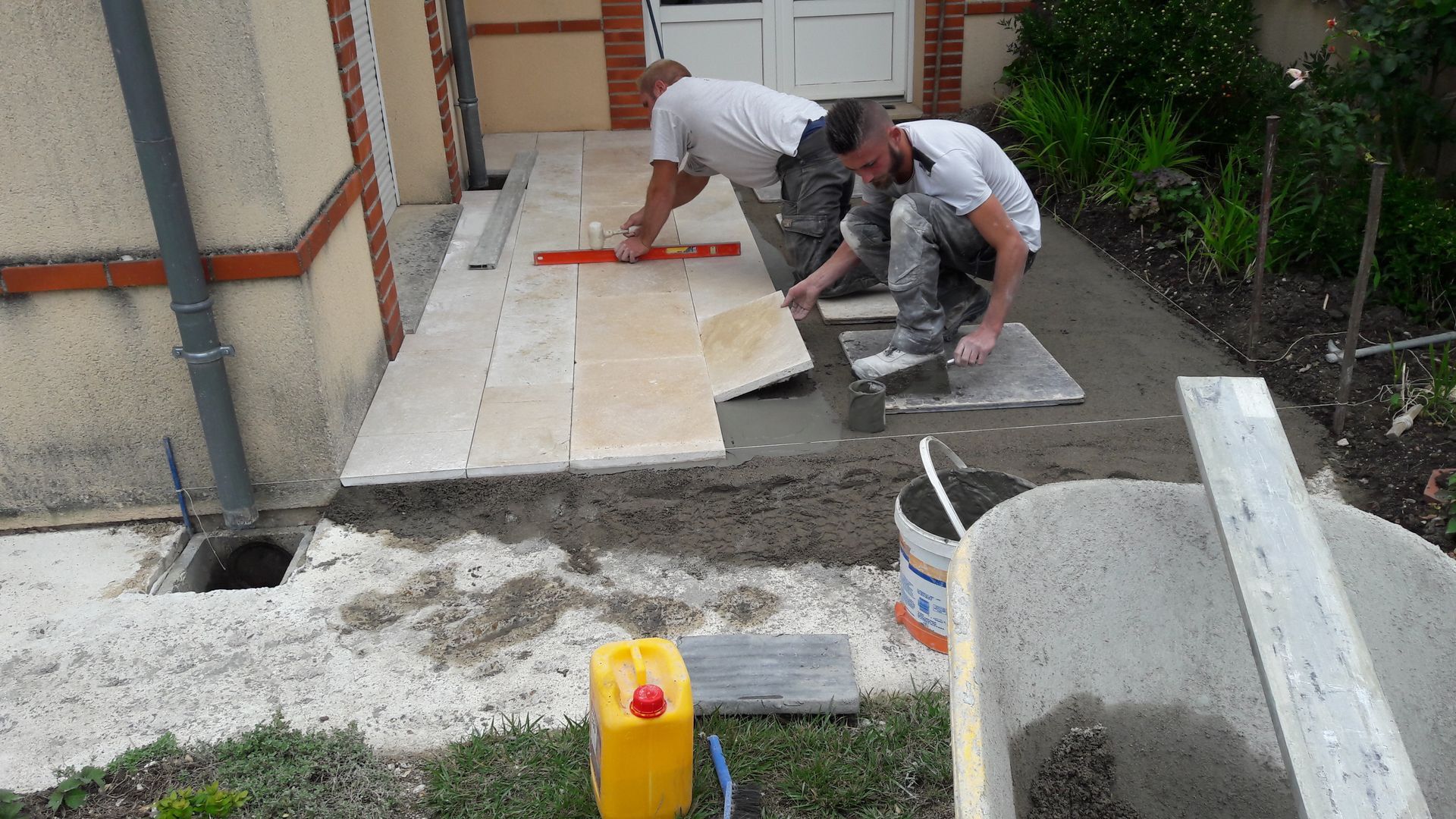 Artisans maçons posant un dallage