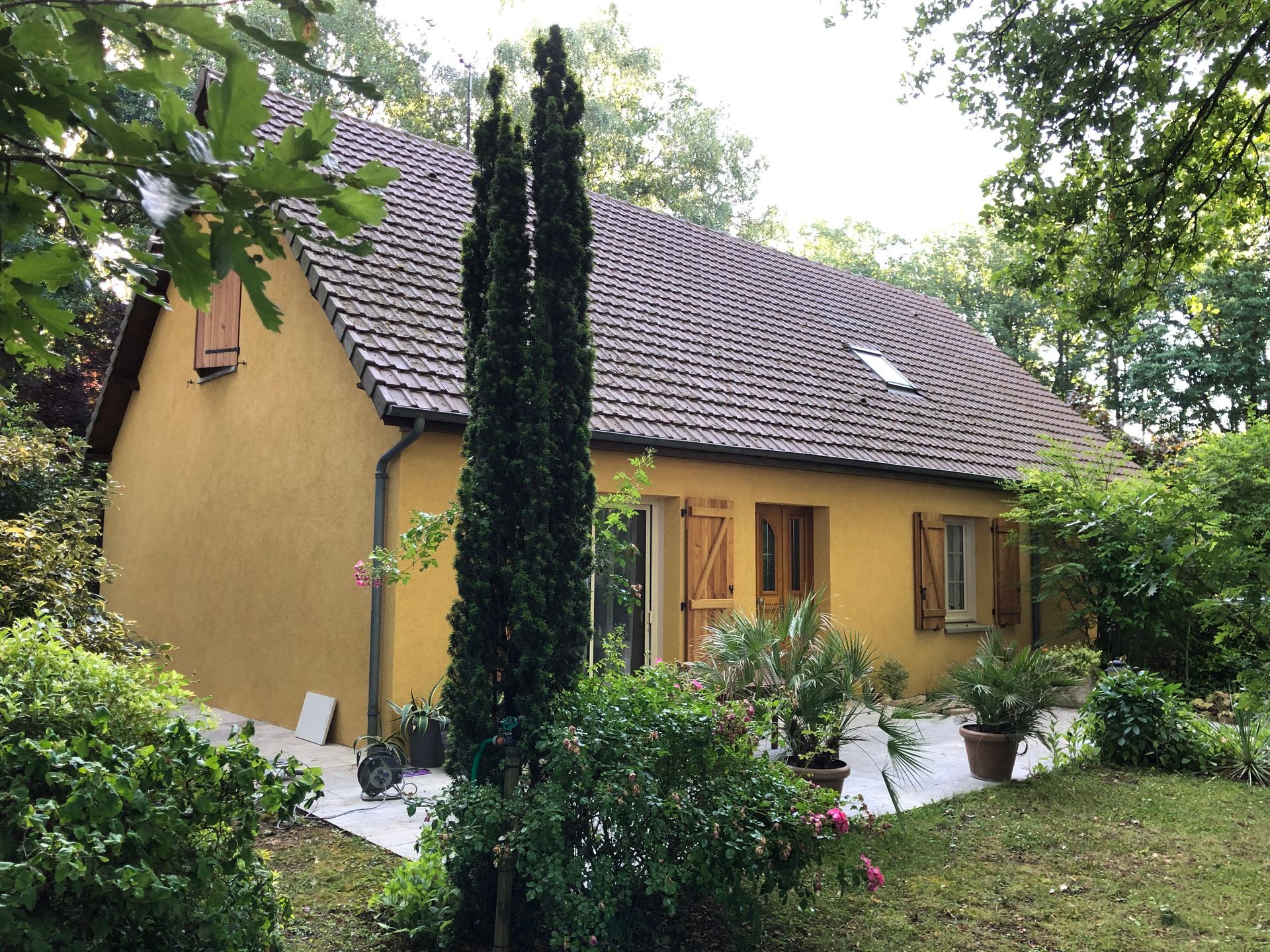 Maison avec façade jaune et aménagement extérieur