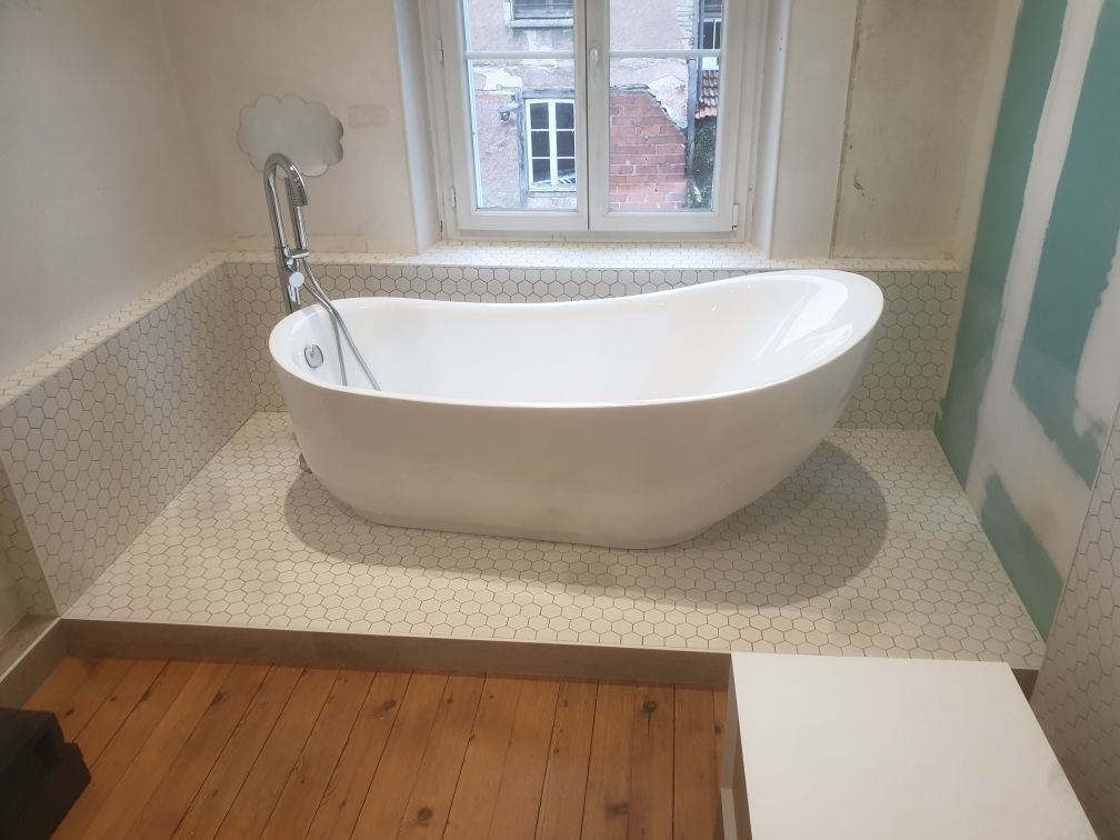 Baignoire îlot posée sur une dalle avec une mosaïque