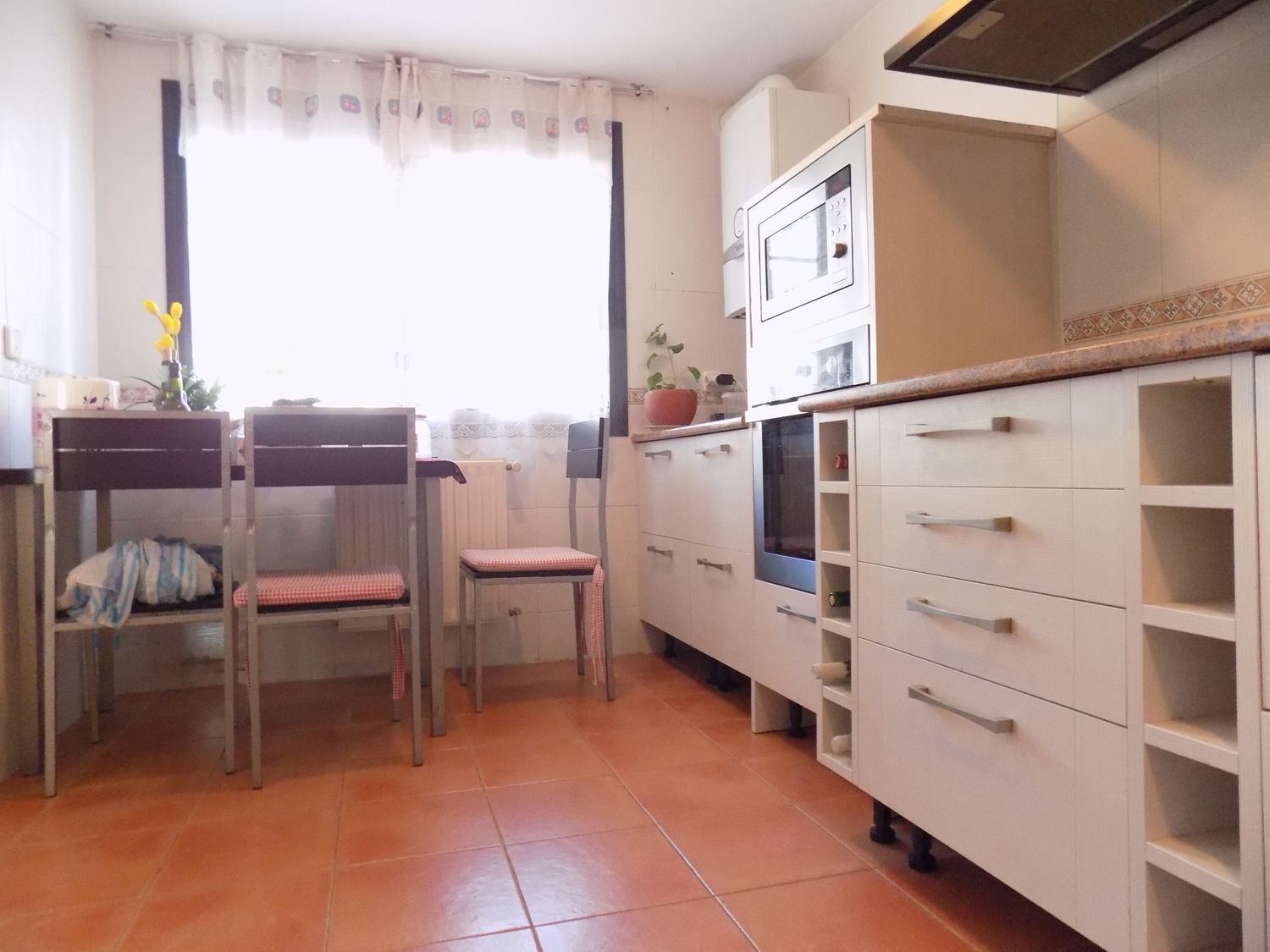 Una cocina con mesa y sillas y una ventana.