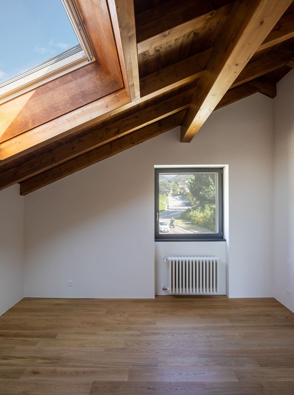 Una habitación vacía con un tragaluz y una ventana.