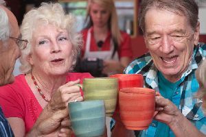Senioren stoßen mit einer Tasse Tee an