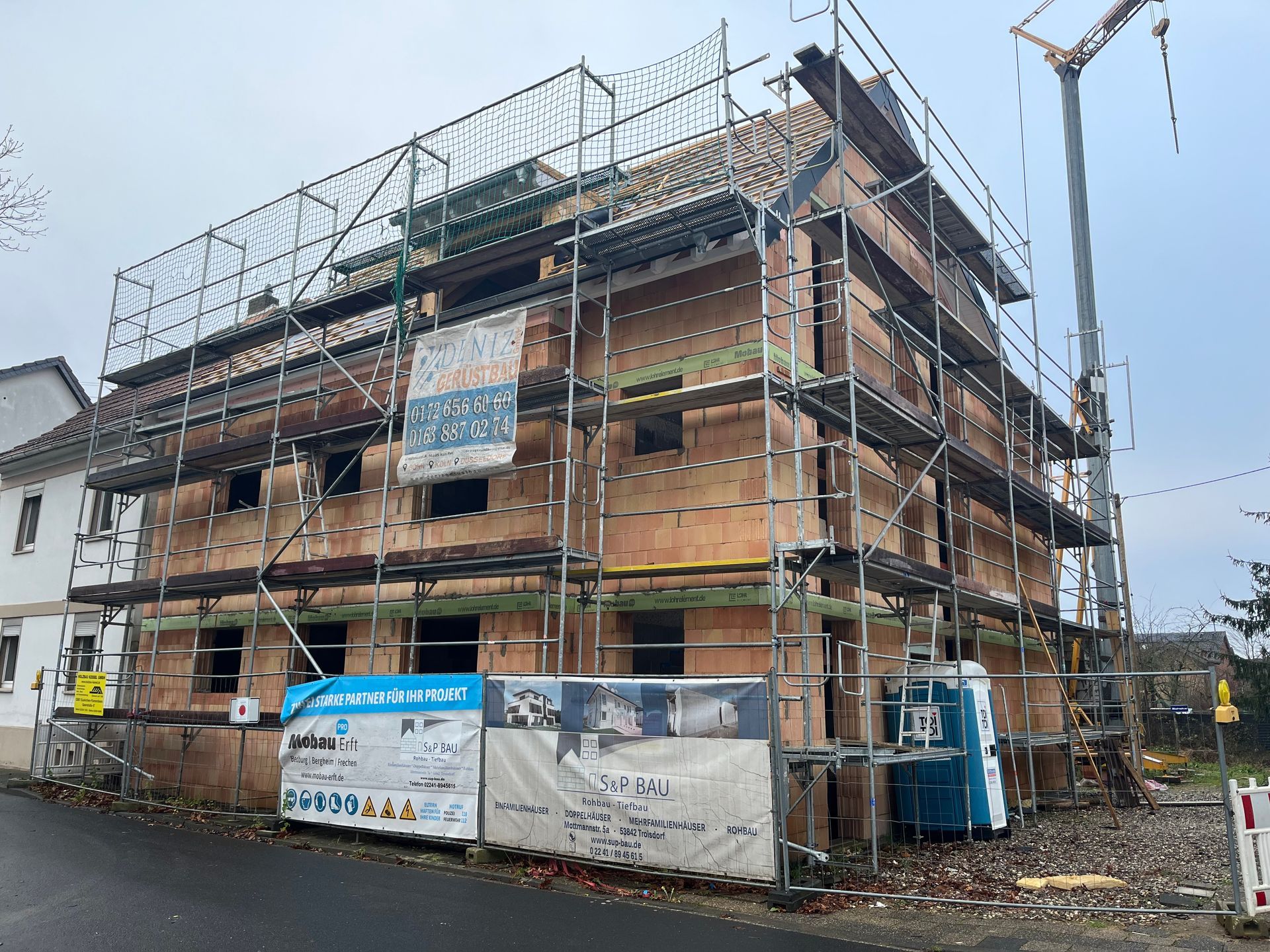 Ein im Bau befindliches Gebäude mit Gerüst und Kran.