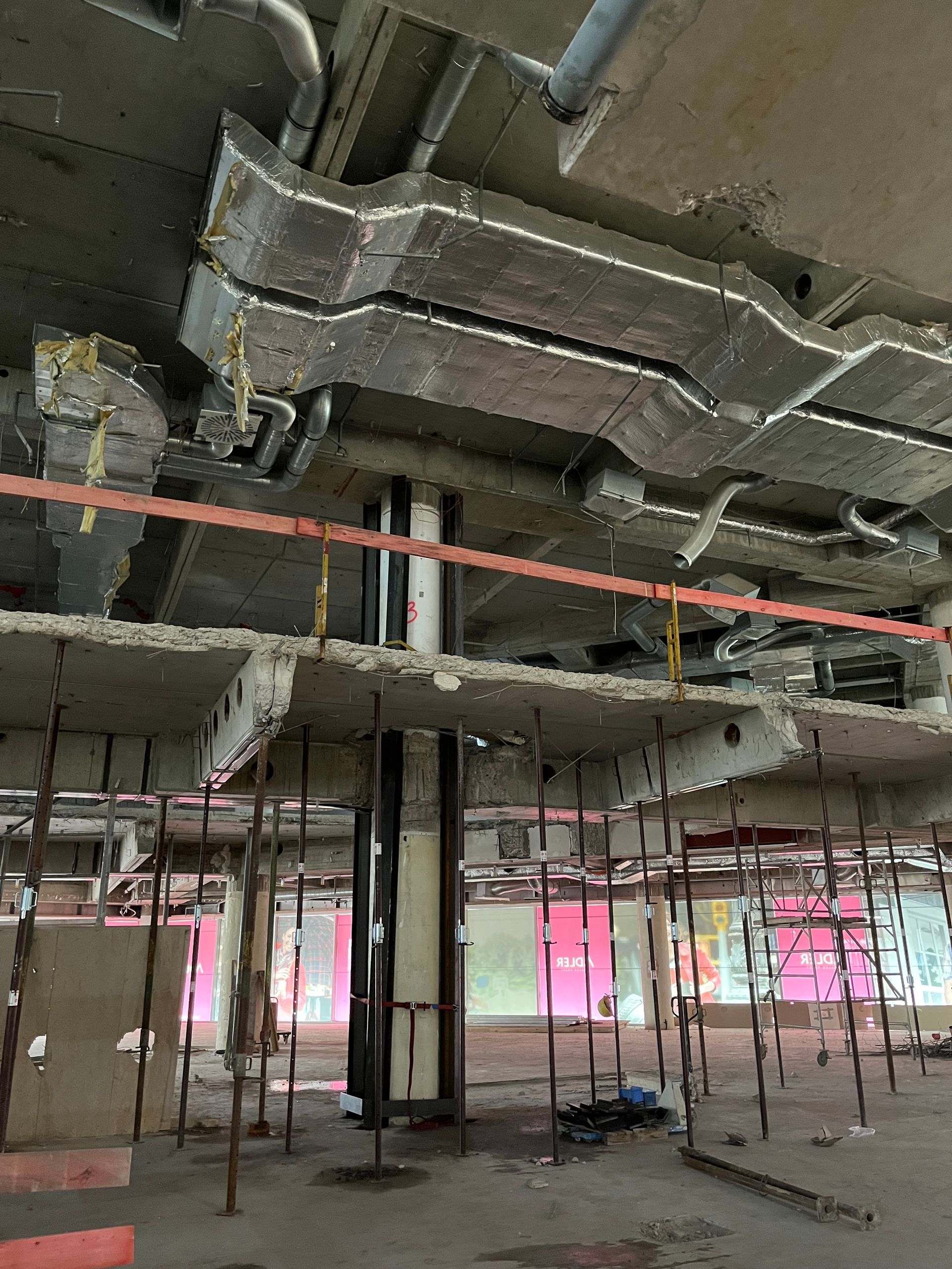 Ein leeres Gebäude mit vielen Rohren, die von der Decke hängen.