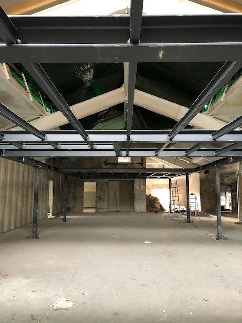 Ein großer leerer Raum mit einer Metallstruktur an der Decke.