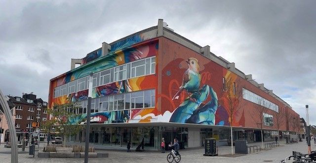 Ein großes Gebäude mit einem Wandgemälde an der Seite.