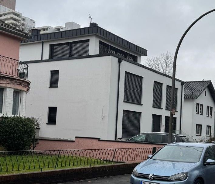 Ein blaues Auto steht vor einem weißen Gebäude