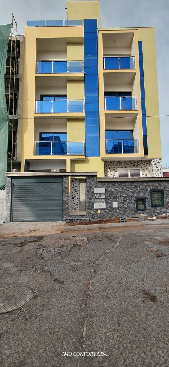 Uma cozinha moderna com mesa de jantar, cadeiras e armários. Um vaso de flores sobre a mesa.
