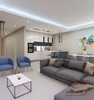 Um espaço de estar moderno e aberto com um sofá secional cinza, poltronas azuis e uma cozinha branca.