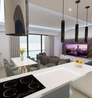 Cozinha moderna com ilha branca e fogão preto, aberta para uma sala de estar com sofá cinza e vista para a cidade.