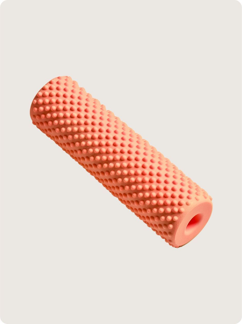 A textured, orange foam exercise roller with a hollow center, isolated against a neutral background.