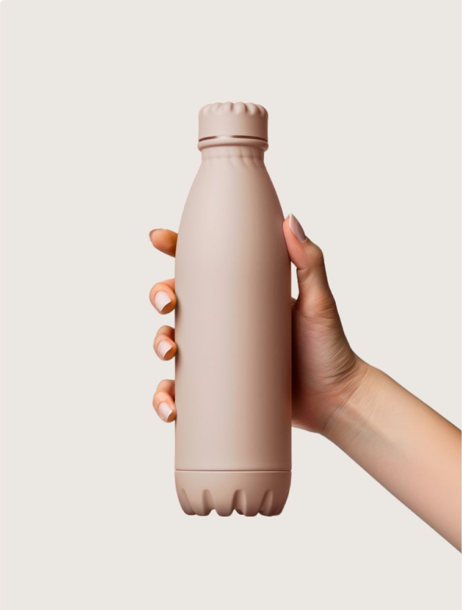 A hand holding a plain, matte-finish dusty pink reusable water bottle against a light beige background.