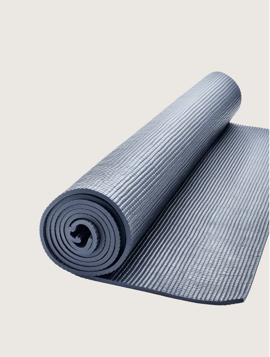 A charcoal gray exercise mat partially rolled up against a plain light background.