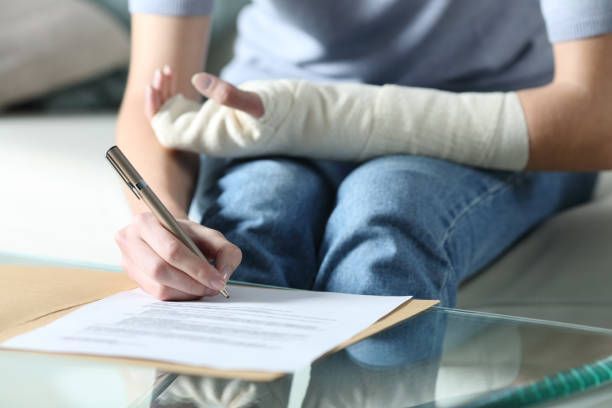 Una persona con un yeso en el brazo está escribiendo en un trozo de papel.